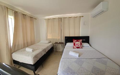 a bedroom with two beds and a window at Caribbean Island Hotel Piso 2 in San Andrés