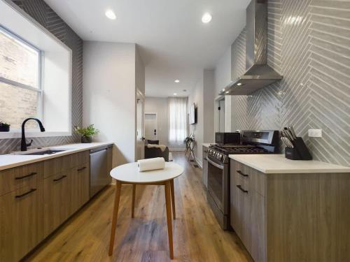 a kitchen with a table and a sink and a stove at West Town 2BR with In-Unit Laundry and Onsite Parking in Chicago