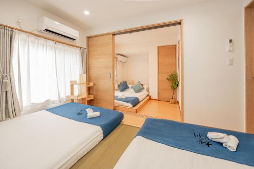 a bedroom with two beds and a mirror at 桜の川30 Shin-okubo subways 5 mins,more than 11 people,big mansion in Tokyo