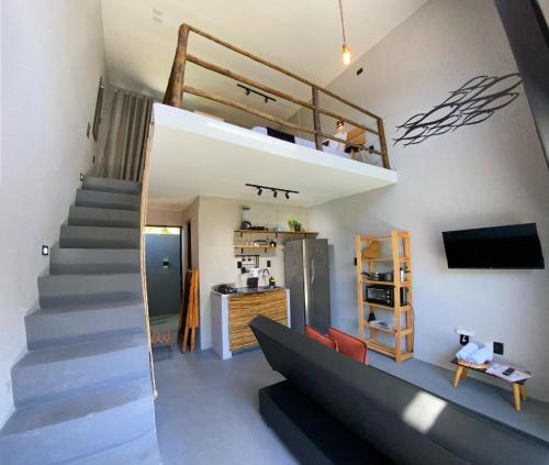 ein Wohnzimmer mit einer Treppe und einem Loft in der Unterkunft LOFT Rio 102 - Refúgio Romântico Inclusivo com Piscina Privativa - bem prox a Vilas Gastronômicas, Polo de Artesanato e Associação Peixe-boi in Pôrto de Pedras