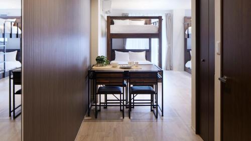 a dining room with a table and chairs and a bunk bed at Minn Kamata in Tokyo