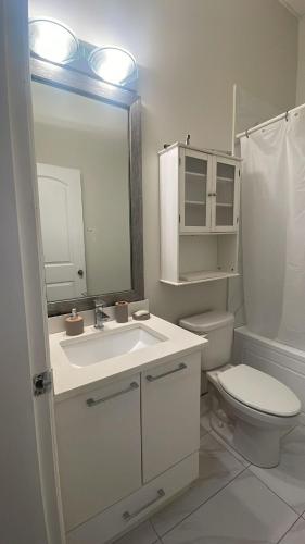 a bathroom with a sink and a toilet and a mirror at 3 Bed - Best View in Town! in Surrey
