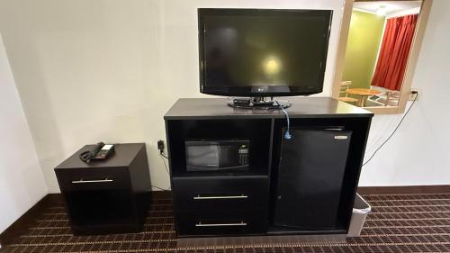a tv sitting on top of a black entertainment center at Executive Inn in Warner Robins