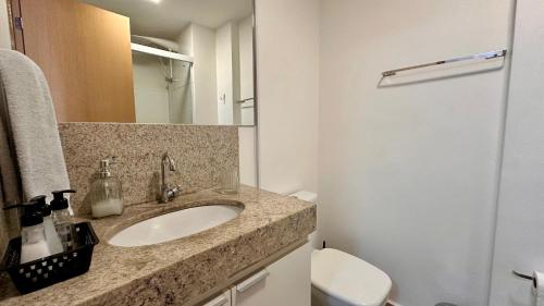 a bathroom with a sink and a toilet and a mirror at AP1607 ar cond piscina academia coworking etc in Juiz de Fora