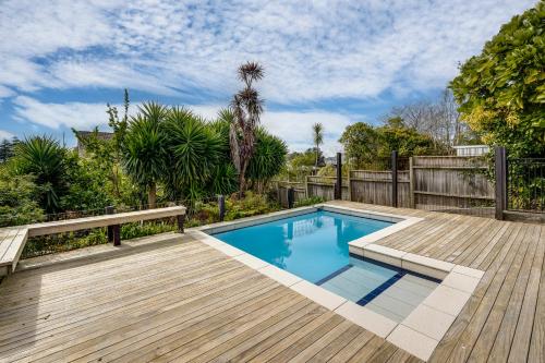 a swimming pool on a wooden deck with a wooden fence at 7th Heaven - Bluff Hill, Napier in Napier