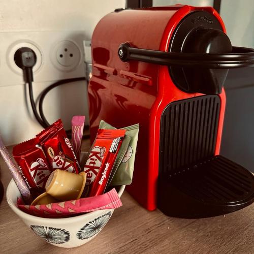 a bowl of chips and candy next to a toaster at Studio Charme et confort 30m2, près de versailles in Marly-le-Roi
