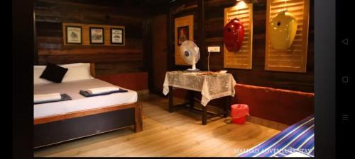 a bedroom with a bed and a table in a room at Aranya a wild forest ecostay in Kalasa
