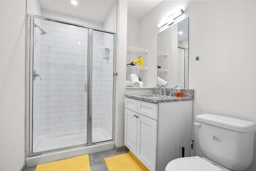 a white bathroom with a shower and a toilet at CozySuites Stunning 1BR in Downtown Pitts #12 in Pittsburgh