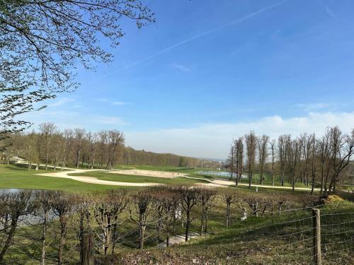 a view of a golf course with trees and a pond at Studio Charme et confort 30m2, près de versailles in Marly-le-Roi