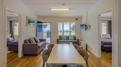 a room with a table and a couch and a bedroom at Stay Rottnest in Rottnest Island