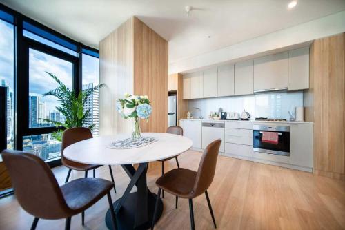 a kitchen with a white table and chairs and a kitchen with at Sky-High CBD Living Walk to Everything in Sydney