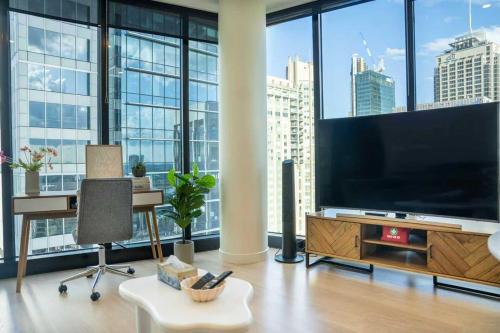 a living room with a large flat screen tv at Sky-High CBD Living Walk to Everything in Sydney