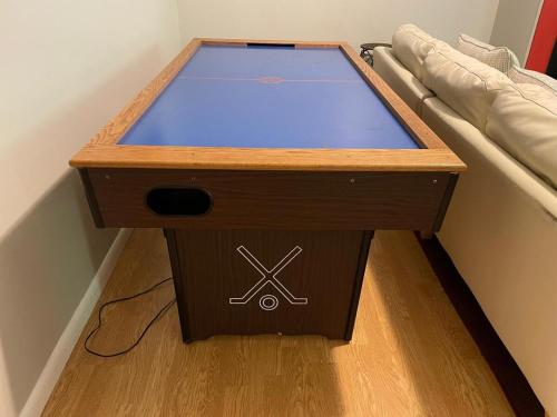 a wooden table with a laptop on it next to a couch at Luxury Mountain Villa - 3 bedroom, hot-tub, fire-pit in Hunter