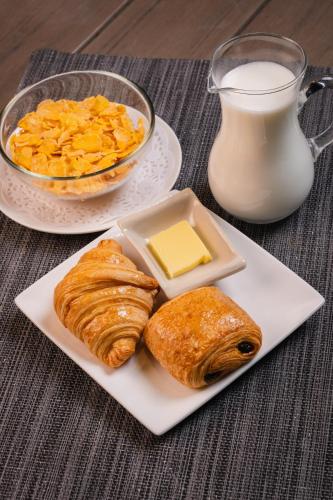 a plate of food with pastries and a glass of milk at TUI BLUE Maduzi Hotel Bangkok in Bangkok