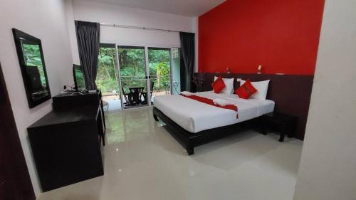 Nathon BayにあるSiva Houseの赤い壁のベッドルーム1室(ベッド1台付)