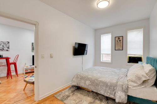 a bedroom with a bed and a flat screen tv at Cozy Condo Jersey City in Jersey City