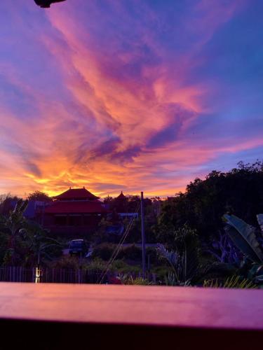a sunset with a purple and pink at Tropical Private Bungalow Oasis Kemuning Bukit in Ungasan