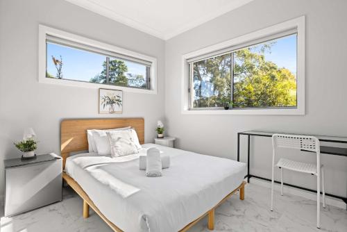 a white bedroom with a bed and two windows at Bright Detached Double Room - Near Top Ryde City Shared Amenities in Sydney