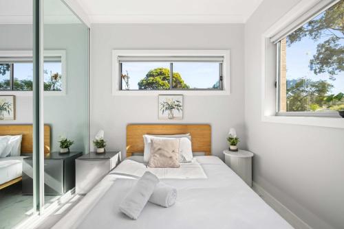 a white bedroom with two beds and two windows at Bright Detached Double Room - Near Top Ryde City Shared Amenities in Sydney