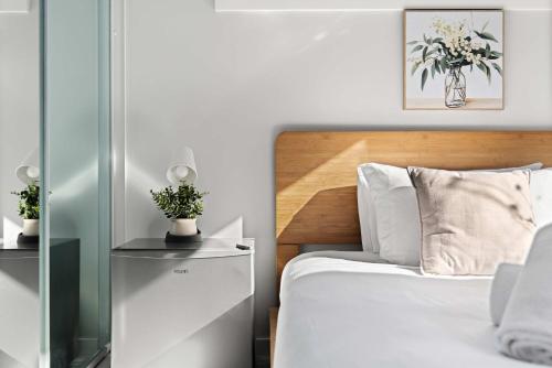a bedroom with a bed with a wooden headboard at Bright Detached Double Room - Near Top Ryde City Shared Amenities in Sydney