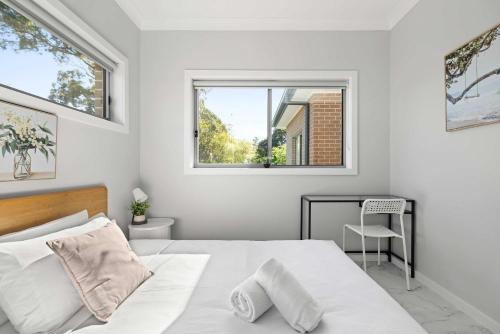 a white bedroom with a bed and a desk at Bright Detached Double Room - Near Top Ryde City Shared Amenities in Sydney