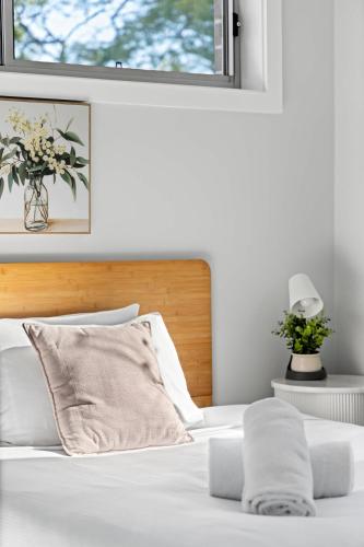 a white bed with a wooden headboard and a window at Bright Detached Double Room - Near Top Ryde City Shared Amenities in Sydney