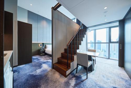 a room with a table and a staircase in a building at Hotel HLB in Busan
