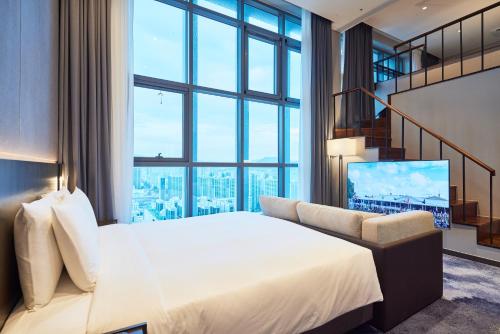 a hotel room with a bed and a large window at Hotel HLB in Busan