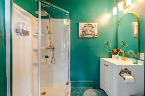 une salle de bain verte avec une douche et un lavabo dans l'établissement MerManor in Soda Pop District, à Wilmington