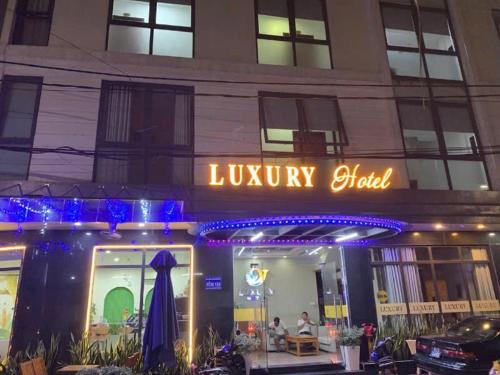 Un hotel de lujo con un cartel en el lateral de un edificio. en Khách sạn LUXURY, en Kon Rung (1)