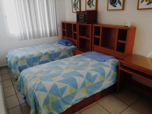 a bedroom with two beds and a table and a desk at Casa en Coto amueblada in Mezcales