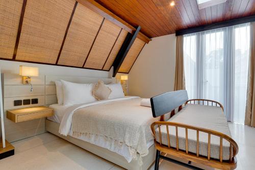 een slaapkamer met een bed, een stoel en een raam bij Luxury 5BR Villa Byrdland Pasisi - Canggu in Canggu