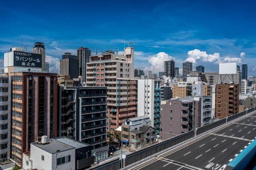 a view of a city with tall buildings and a highway at ESLEAD HOTEL Namba Dotonbori East in Osaka