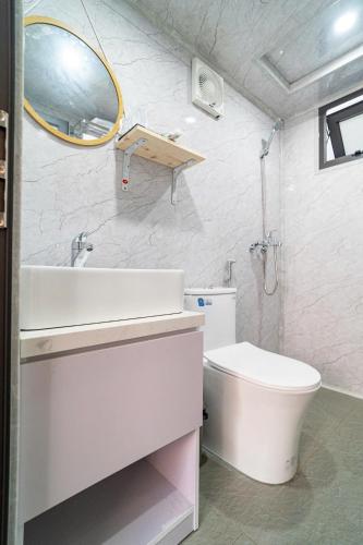 a bathroom with a sink and a toilet and a mirror at Lu's Homestay in Dong Hoi