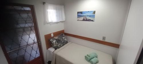 une petite pièce avec un lit et une fenêtre dans l'établissement Quarto Solteiro, à Irati