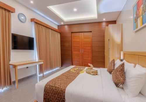 a hotel room with a bed and a desk at Winar Villa Canggu in Munggu