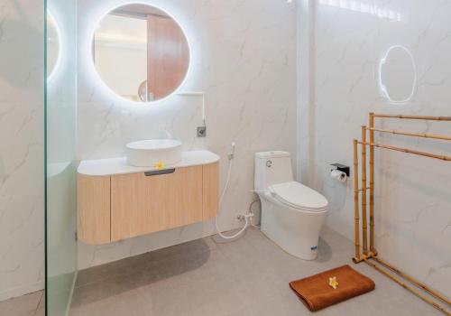 a bathroom with a toilet and a sink and a mirror at Winar Villa Canggu in Munggu