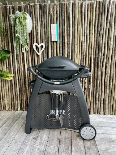 a black stroller on a wooden floor next to a fence at Wairimu View Lodge in Waipu