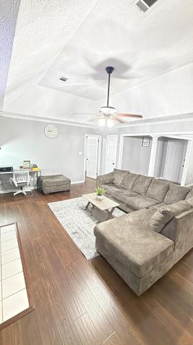 a living room with a couch and a ceiling fan at Private Pool Paradise in Prattville