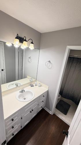 a bathroom with a sink and a large mirror at Private Pool Paradise in Prattville