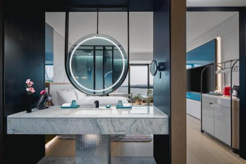 a bathroom with a sink and a mirror at Hotel Indigo Suzhou Jinji Lake by IHG in Suzhou