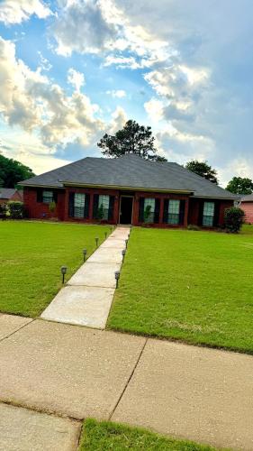 a house with a grassy yard in front of it at Private Pool Paradise in Prattville