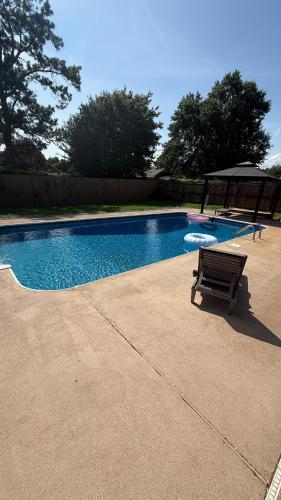 a bench sitting next to a swimming pool at Private Pool Paradise in Prattville