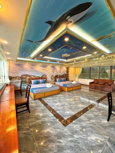 a room with beds and a dolphin painting on the ceiling at Resort Hàng Dương in Blao Klong Ner