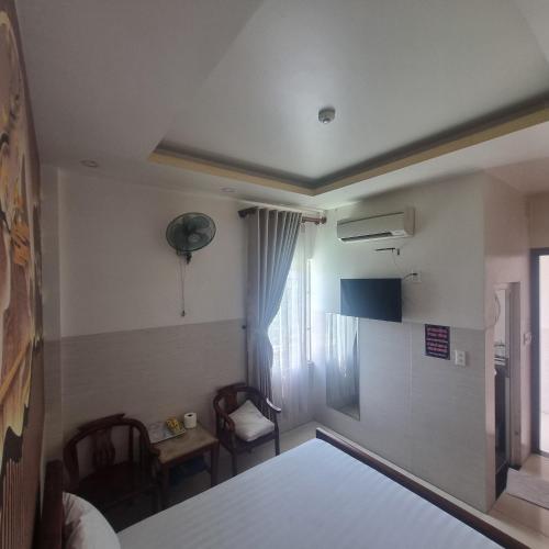 a room with a bed and a table and chairs at KHÁCH SẠN MlLAN in Dĩ An