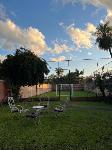 a group of chairs sitting in the grass near a fence at Quinta LA PALOMA in San Lorenzo