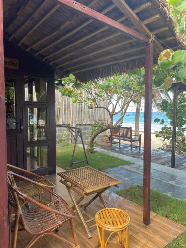 a patio with chairs and a table and a bench at TRÚ HOUSE in Mỹ Quang