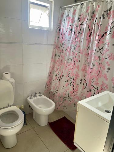 a bathroom with a toilet and a sink and a shower curtain at 4-Espectacular departamento centrico in Morón