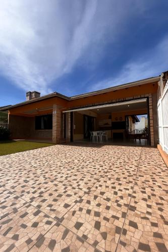 a house with a brick patio in front of it at Ouvir das Ondas - Xangri-lá in Xangri-lá