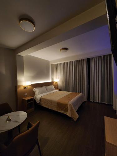 a hotel room with a bed and a table at Hotel Alba in Ica